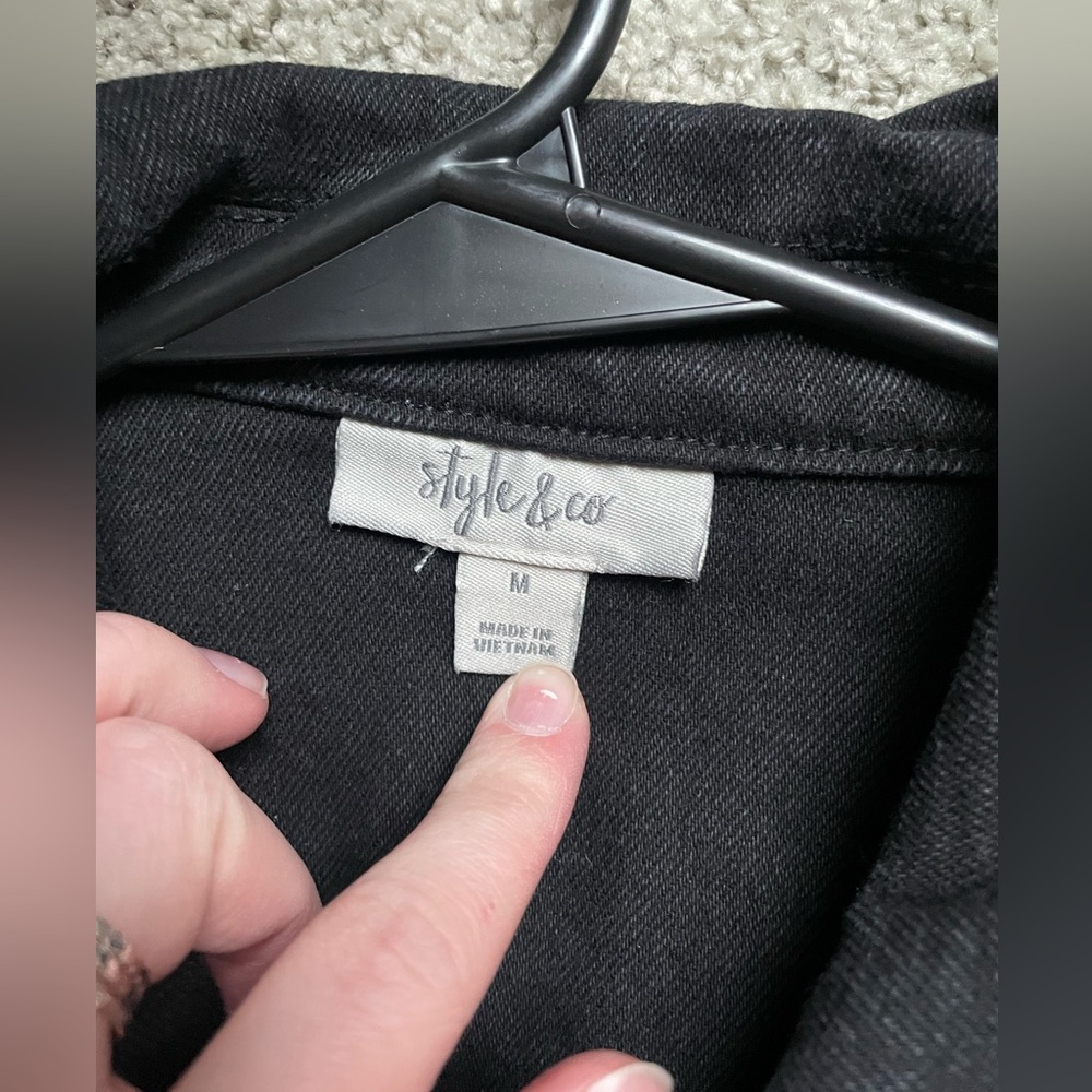 Simple black denim jacket with black metal buttons.
